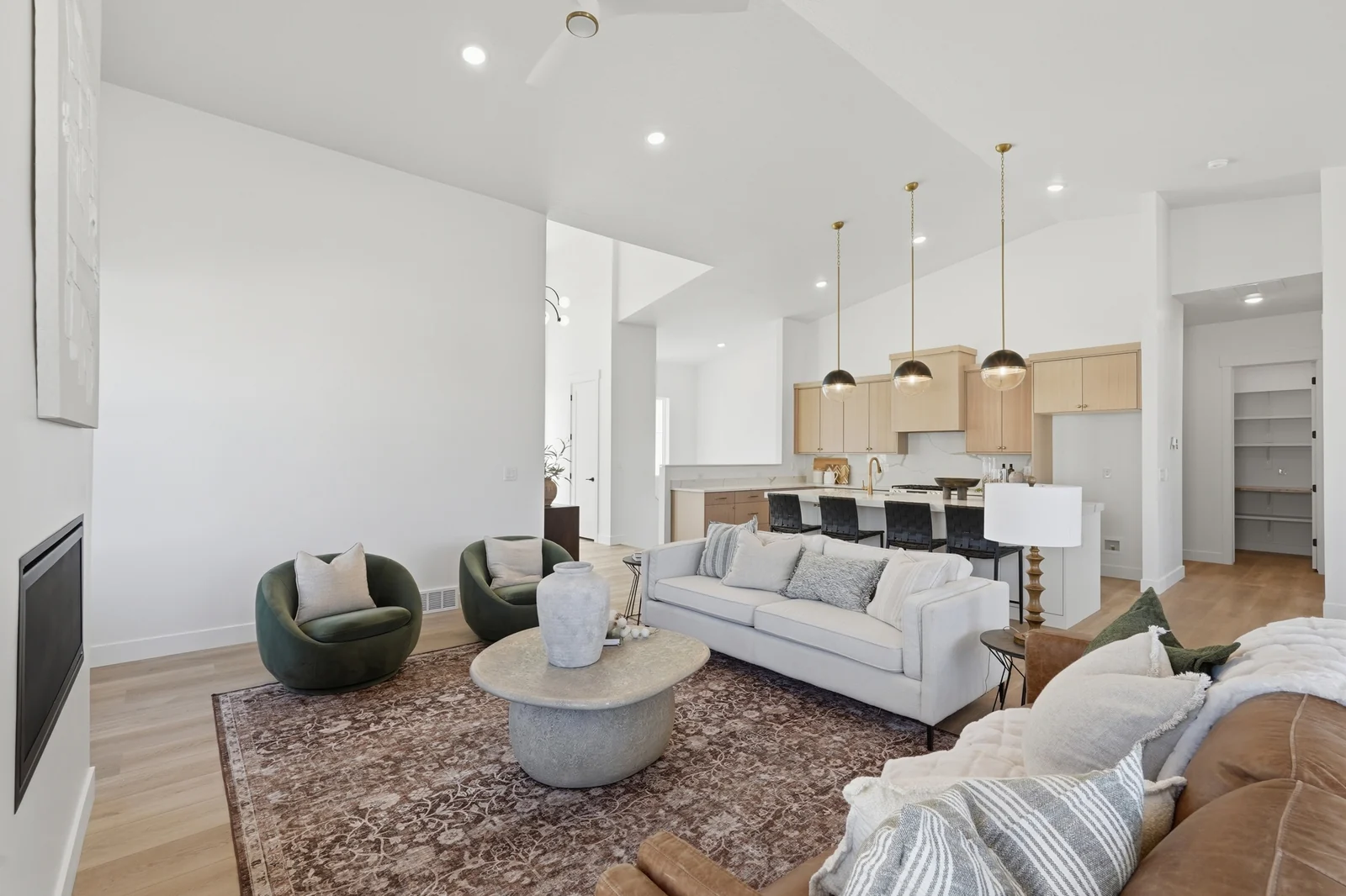 Wide view of the furnished living room opening to the kitchen and dining area in Chestnut Modern MW302, Stansbury Park.