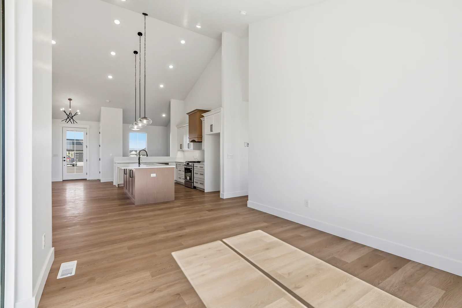 View across the entry flooring toward the open kitchen and living area with stone fireplace at Chestnut MW311, Stansbury Park.
