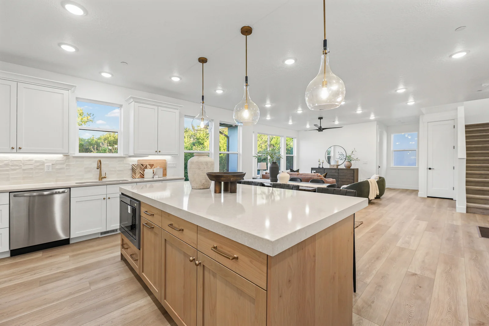 Kitchen island with waterfall-style countertop opens toward the dining and living areas in Hawthorne Farmhouse, Ogden.