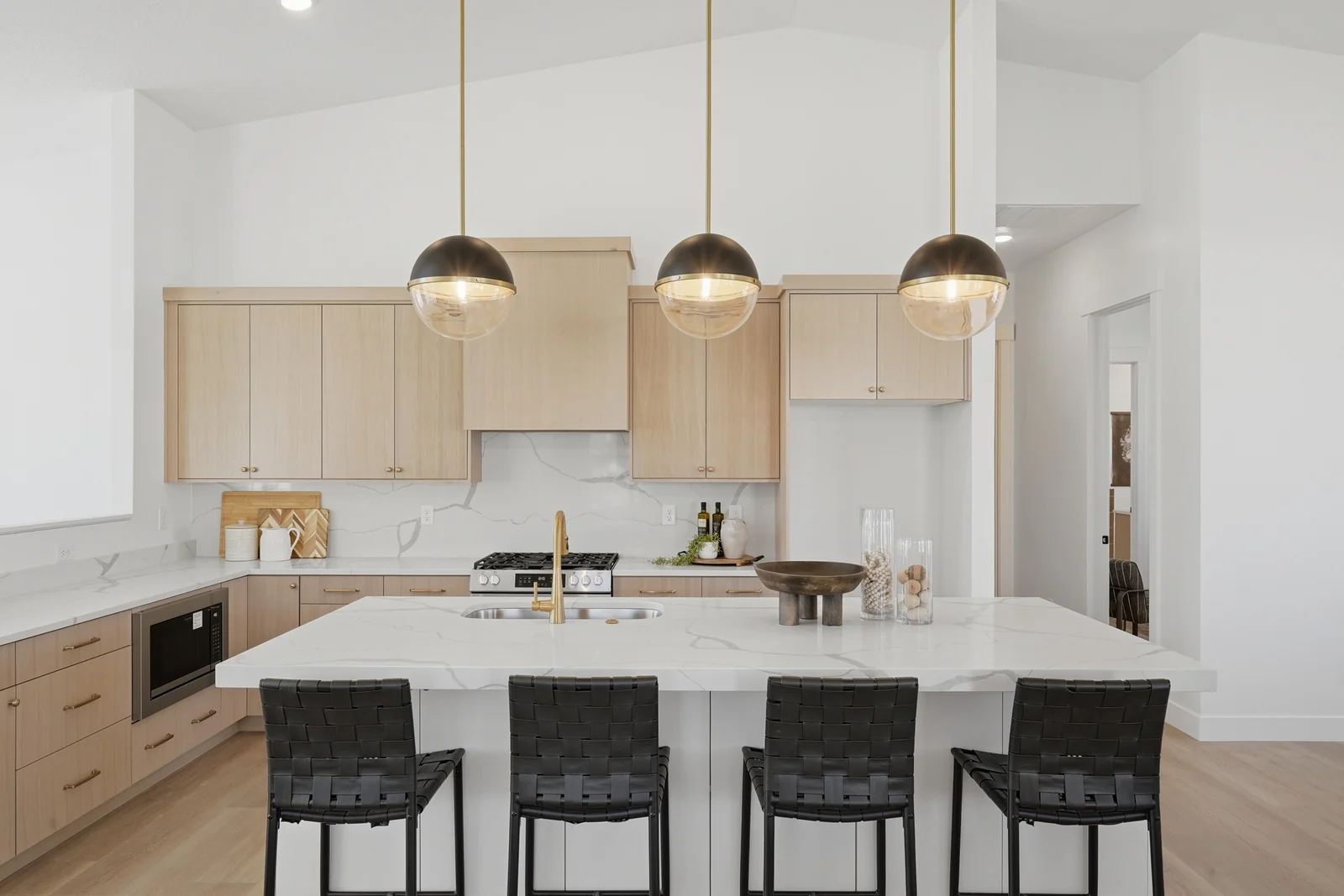 Front-facing view of the kitchen island, cabinetry, range, and pendant lights in Chestnut Modern MW302, Stansbury Park.