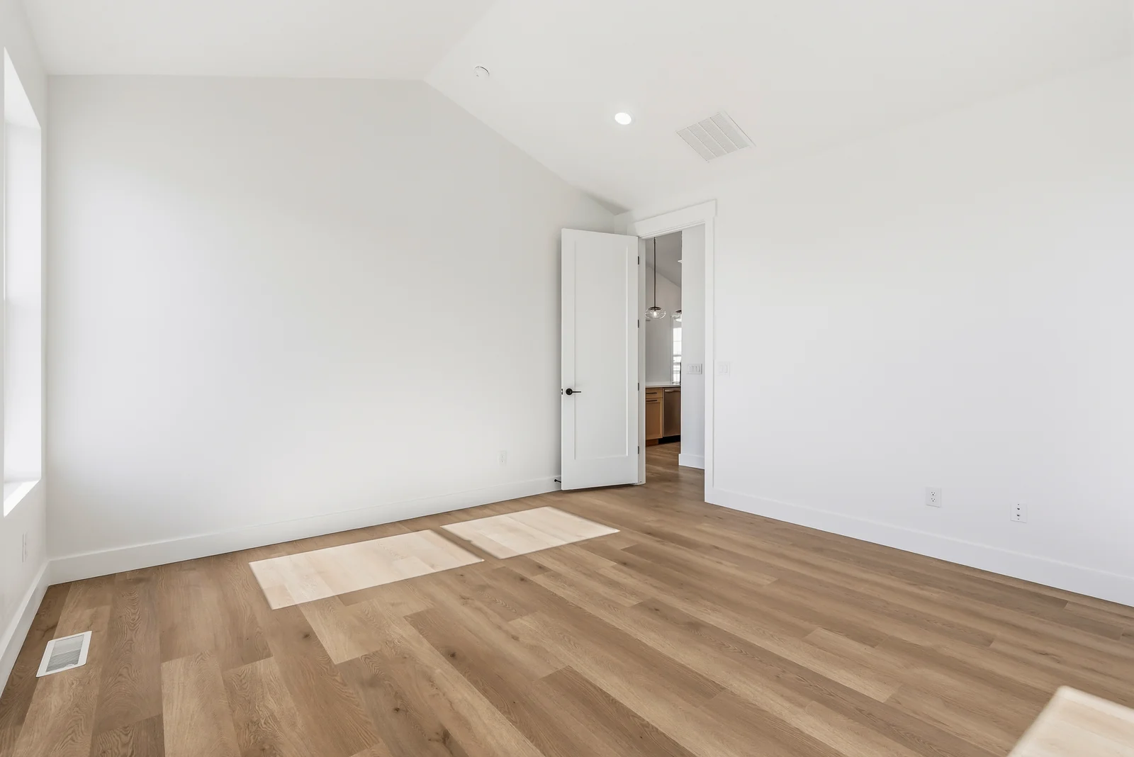 Bedroom with wood-look flooring, recessed lights, closet doors, and an open doorway to an adjoining bathroom at Chestnut MW311, Stansbury Park.