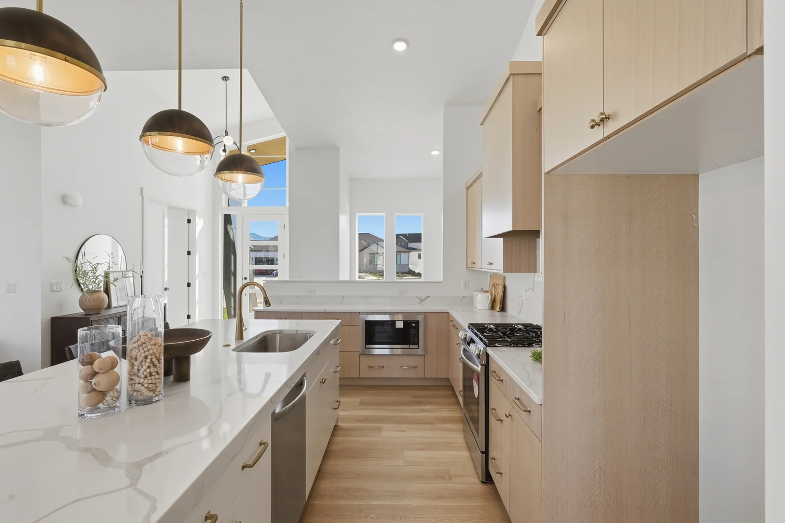 Kitchen work area with long counters, white island, wood cabinetry, and pendant lights in Chestnut Modern MW302, Stansbury Park.