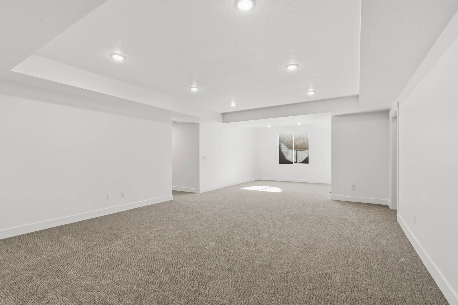 Finished lower-level recreation room with light carpet, recessed lighting, white walls, and a wide open layout at Chestnut MW311, Stansbury Park.