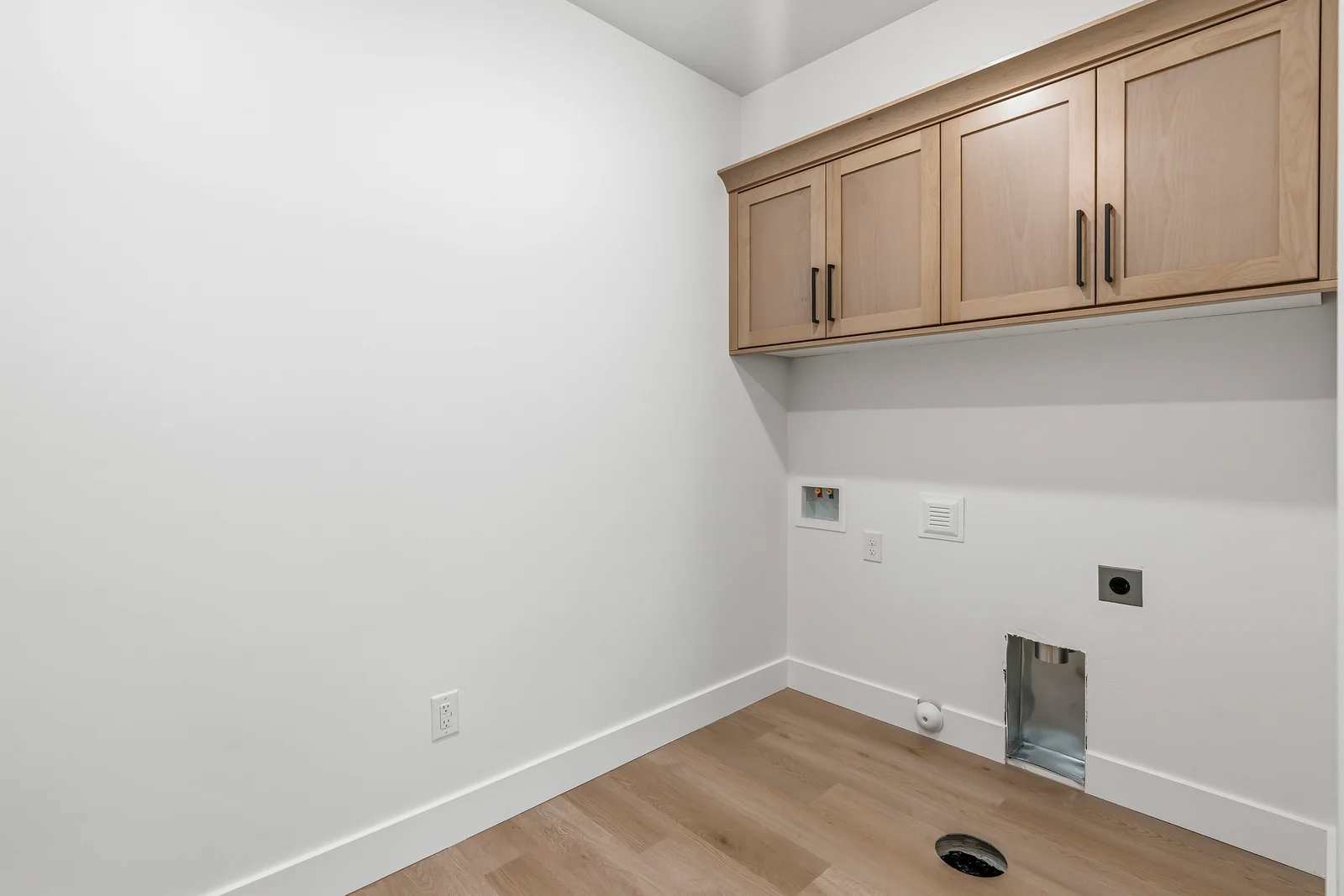 Laundry room with upper wood cabinetry, wall hookups, white walls, and wood-look flooring at Chestnut MW311, Stansbury Park.