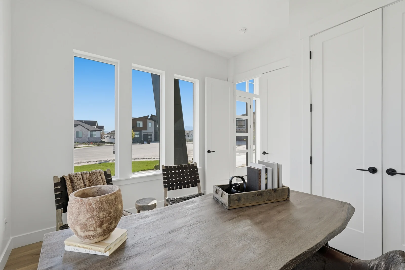 Alternate home office view showing the desk, large windows, glass doors, and upholstered chair in Chestnut Modern MW302, Stansbury Park.