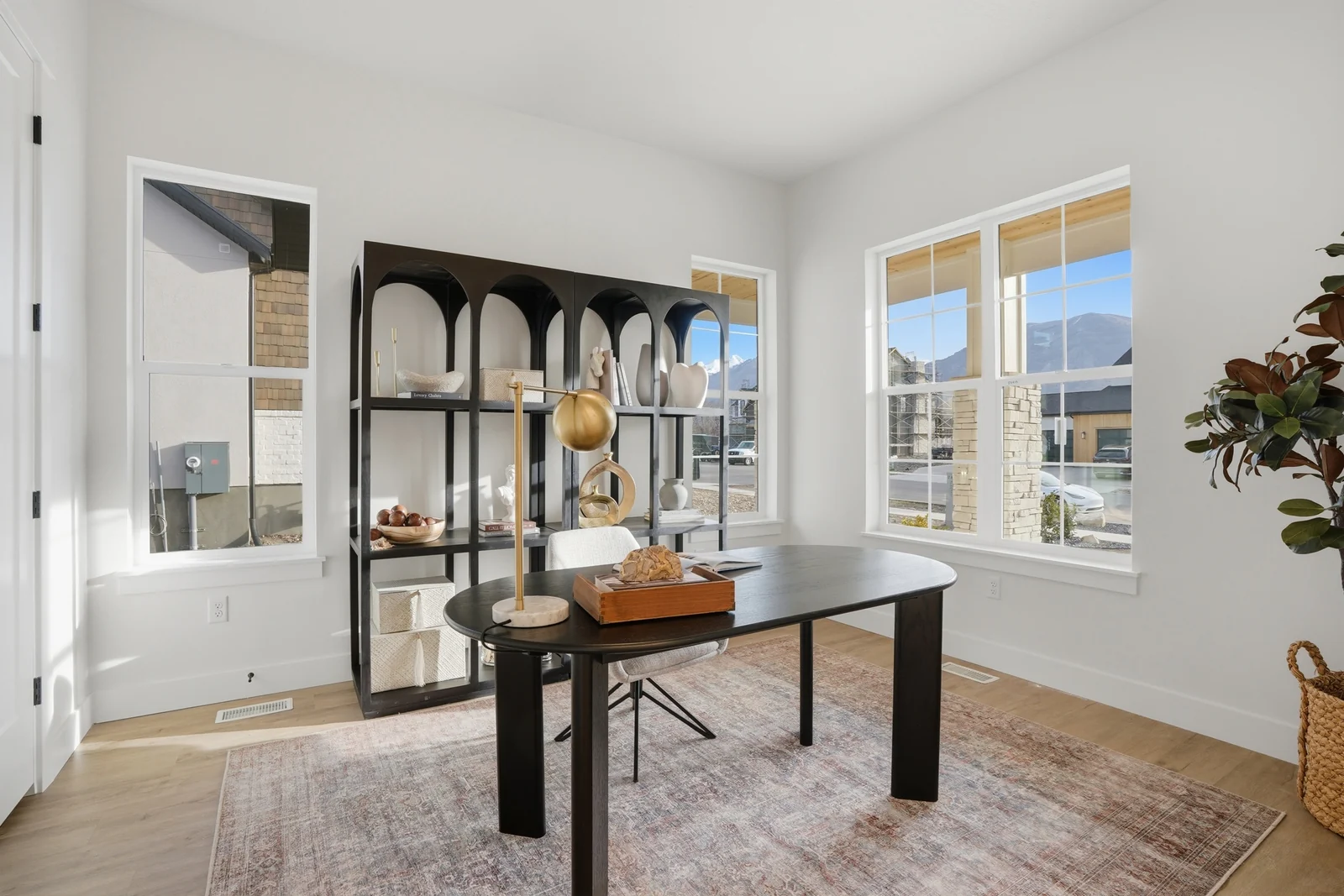 Home office with a worktable, display cabinet, large windows, and wood-look flooring in Olympic BH08, American Fork.