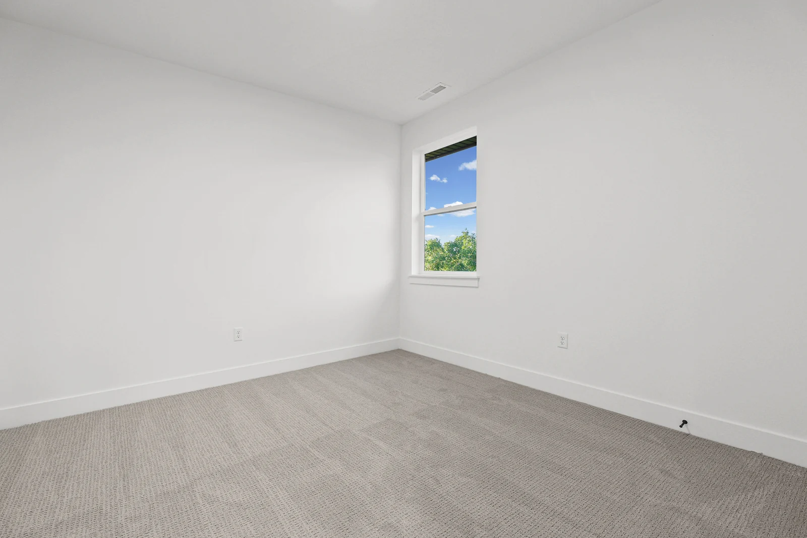 Unfurnished bedroom has gray carpet, white walls, a single window, and recessed ceiling lights in Hawthorne Farmhouse, Ogden.