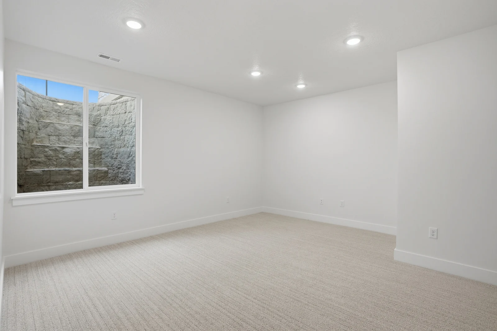 Unfurnished bedroom with recessed lights, neutral carpet, white walls, and an open doorway in Olympic BH08, American Fork.