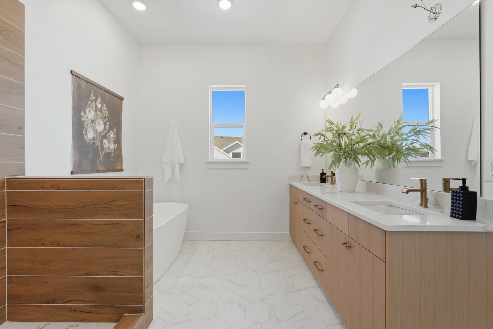 Bathroom view with wood vanity, white counter, freestanding tub, wood accent wall, and tile floor in Chestnut Modern MW302, Stansbury Park.