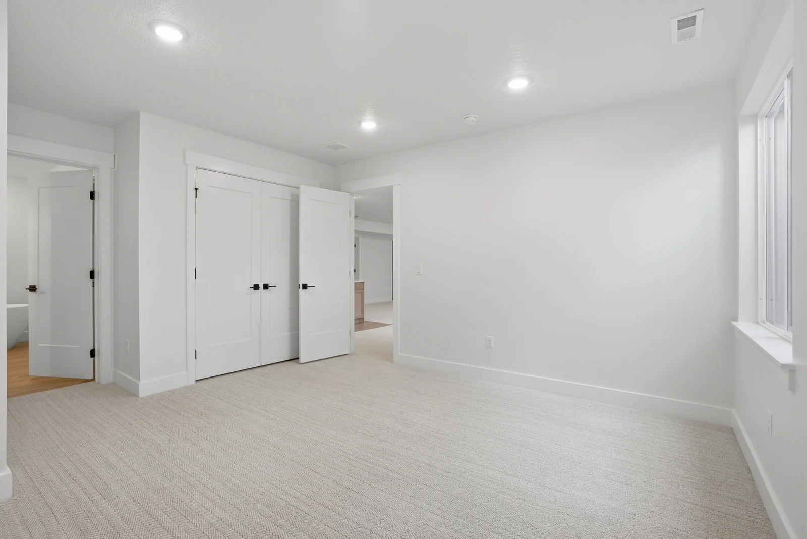 Unfurnished room with a window, recessed lights, neutral carpet, and white interior doors in Olympic BH08, American Fork.