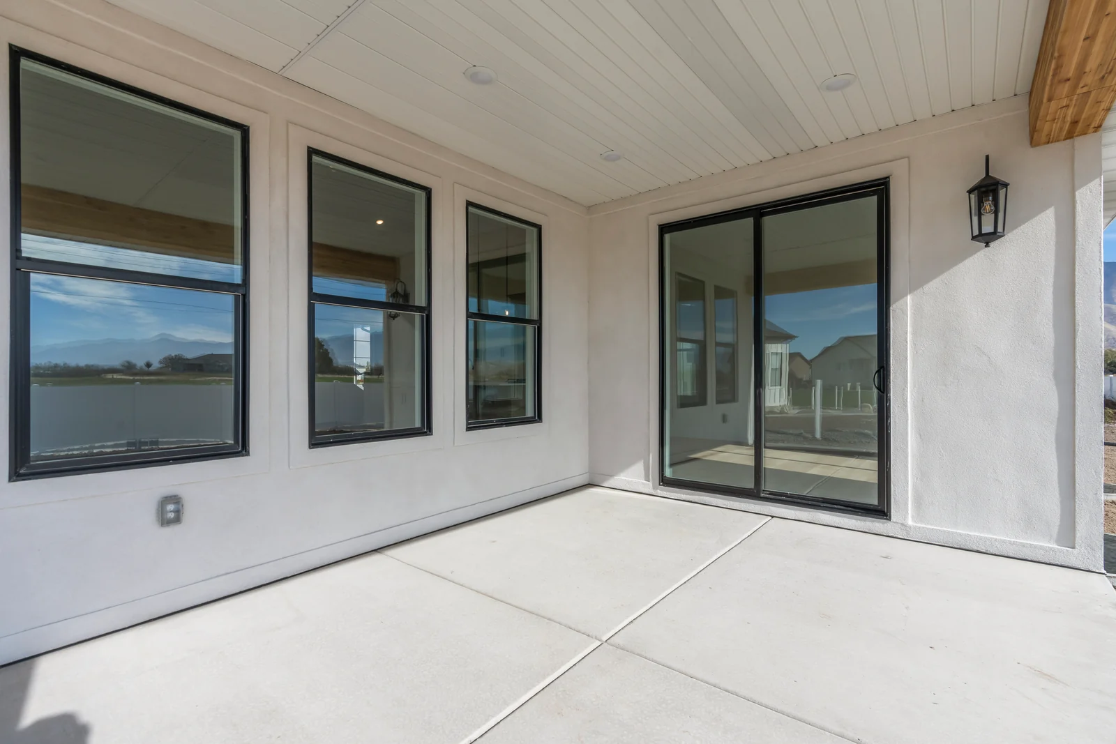 Attached garage interior with concrete floor, overhead door tracks, wall cabinets, and a small side window at Chestnut MW311, Stansbury Park.