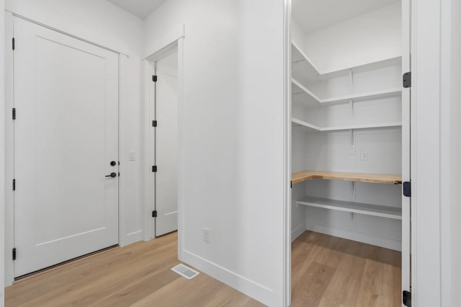Open pantry with white shelving, light wood flooring, and a double-door entry in Chestnut Modern MW302, Stansbury Park.