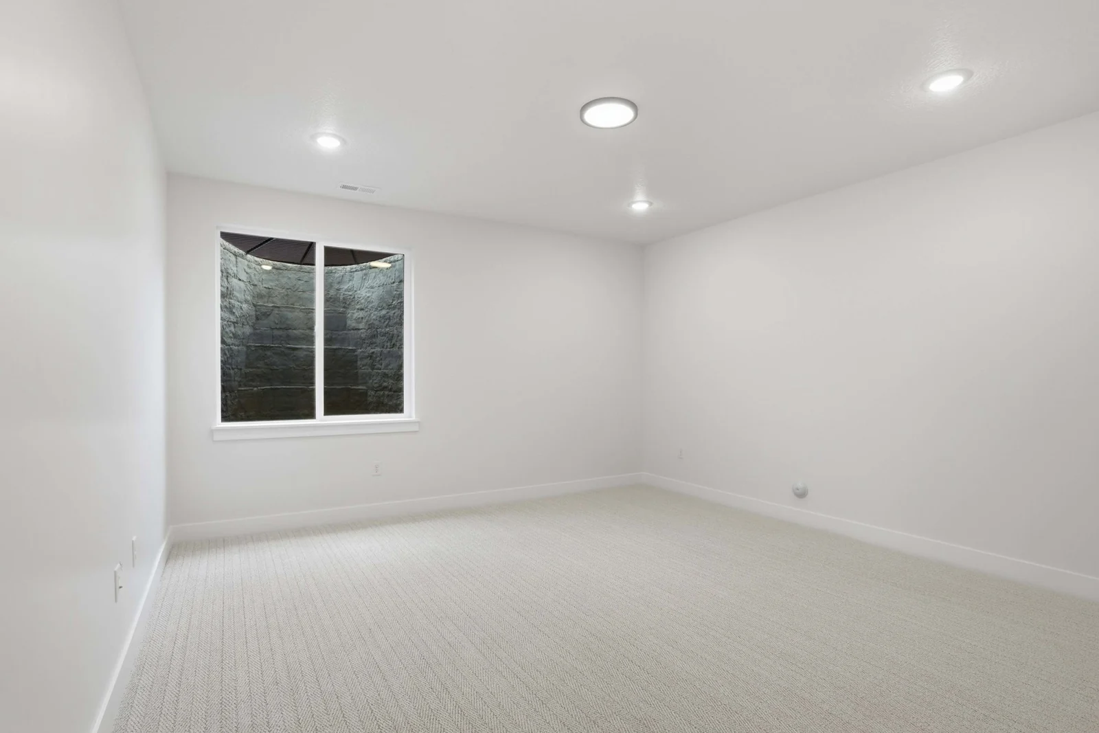 Unfurnished bedroom with pale carpet, recessed lights, a centered window, and simple white walls in the Denali model, American Fork.