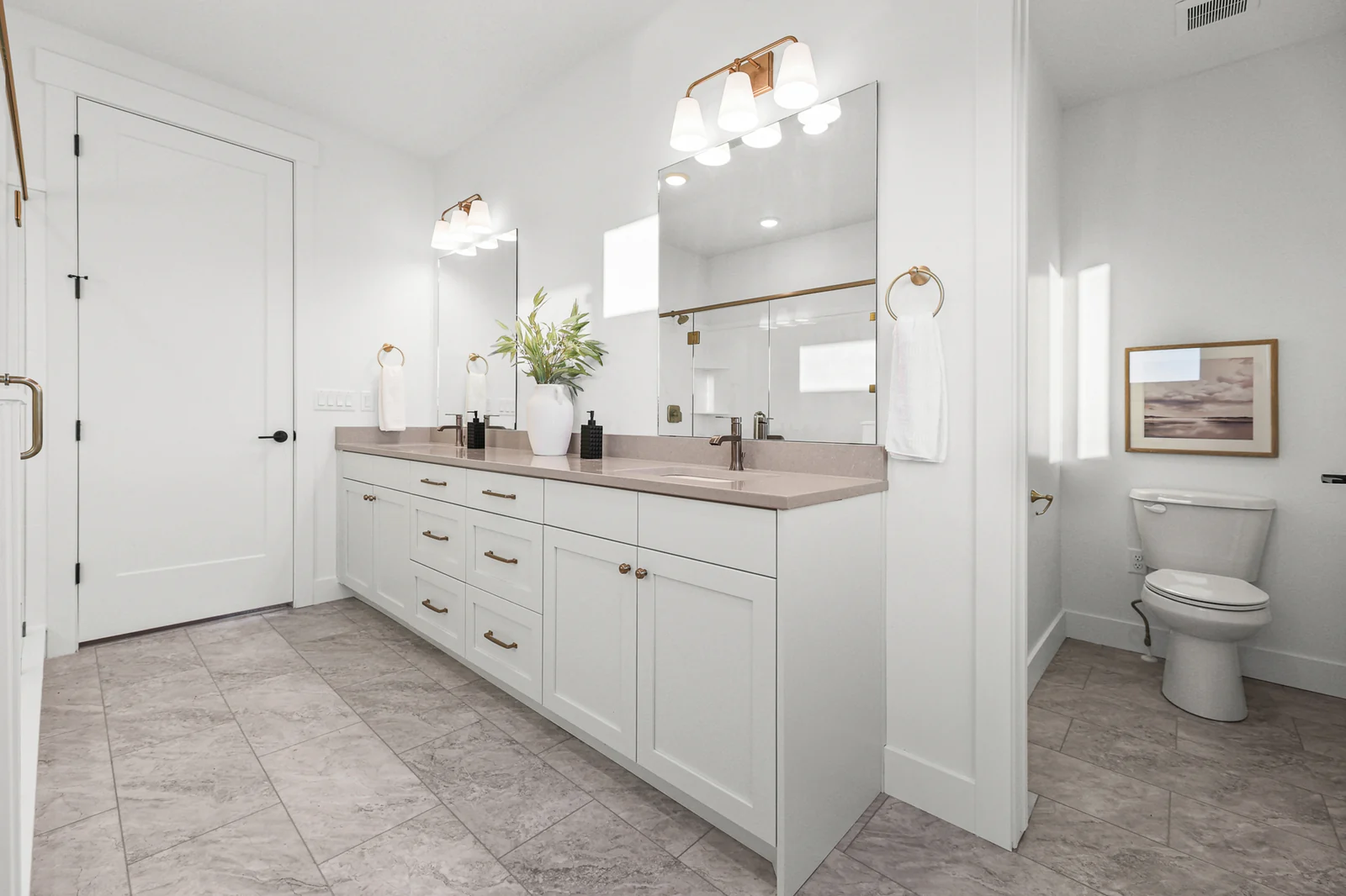 Bathroom includes a double vanity, tiled floor, toilet, glass shower, and freestanding tub in Hawthorne Farmhouse, Ogden.