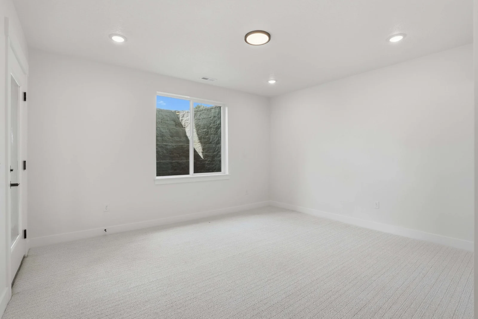 Unfurnished bedroom with recessed lighting, pale carpet, and a window framing distant foothills in the Denali model, American Fork.