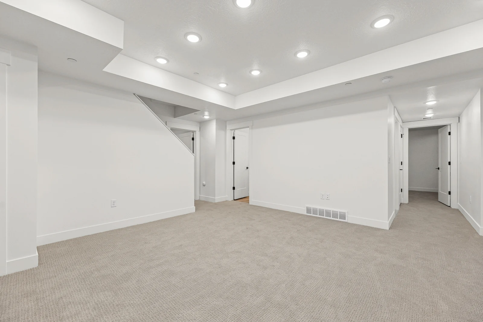 Carpeted lower-level room with recessed lights, stair opening, support column, and adjoining hallway in Hawthorne Modern, Ogden.