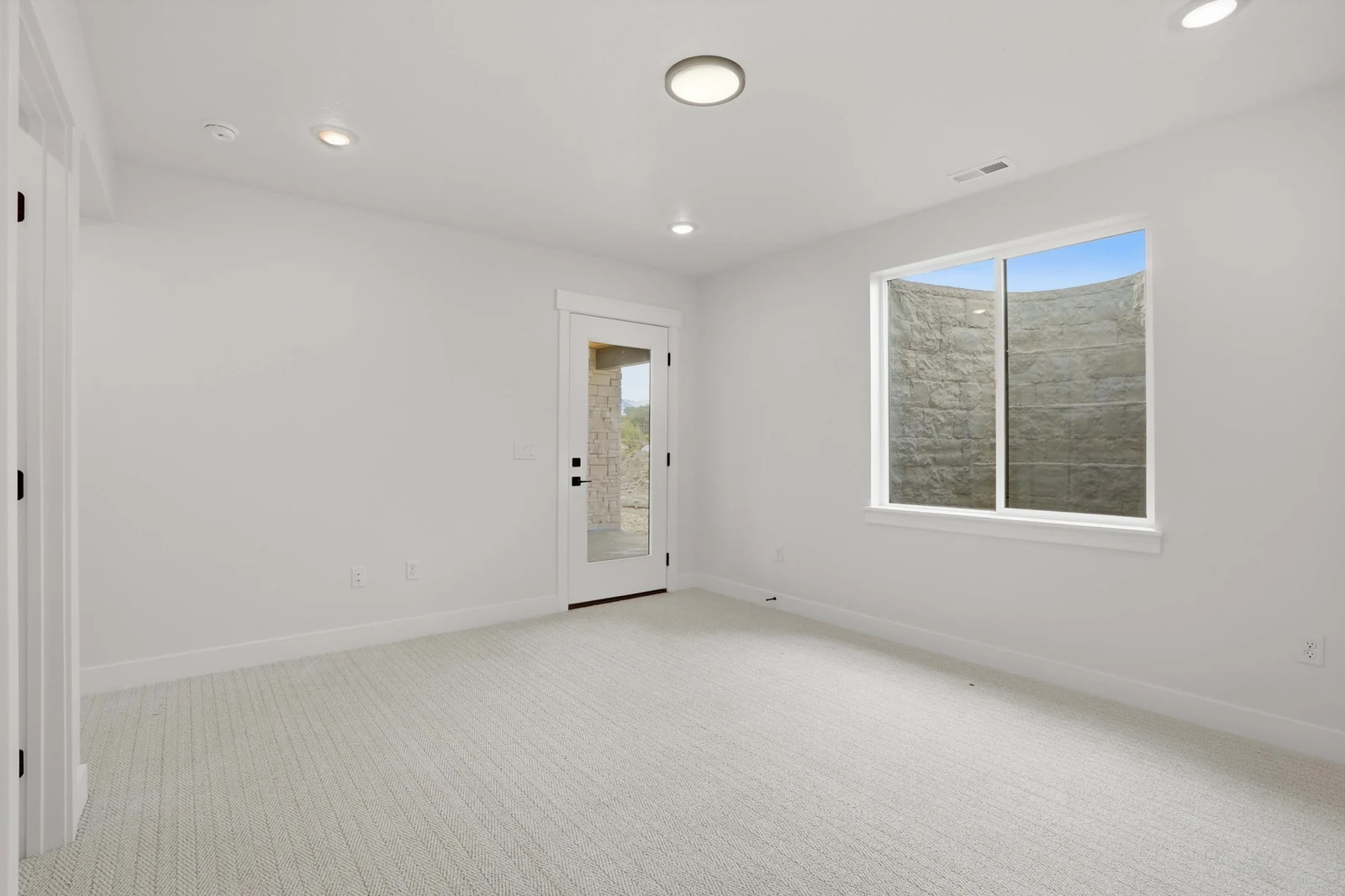 Unfurnished bedroom with pale carpet, recessed lighting, a window, and a glass exterior door in the Denali model, American Fork.