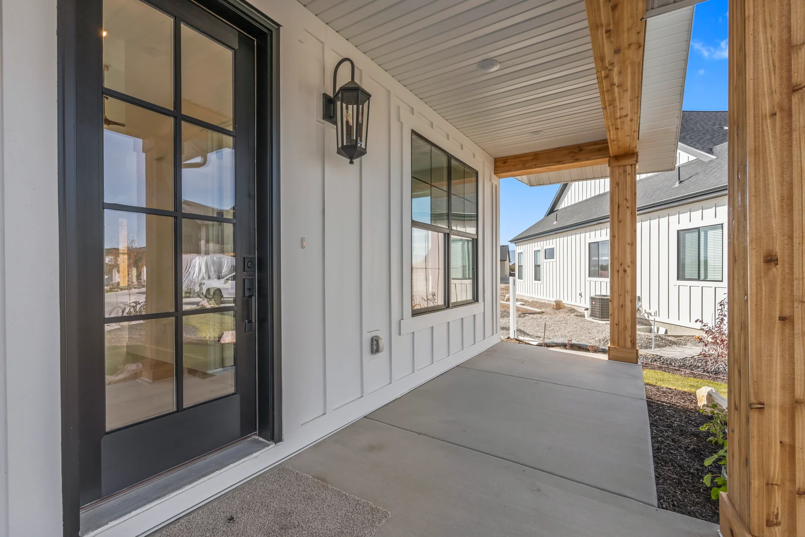 Rear exterior elevation with covered patio, multiple windows, white siding, and unlandscaped yard at Chestnut MW311, Stansbury Park.