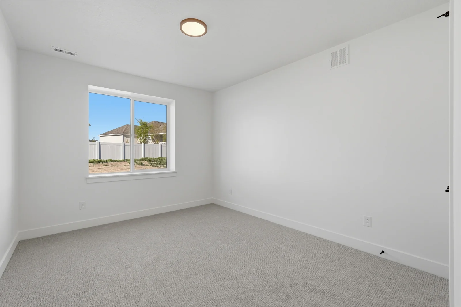 Empty bedroom with white walls, neutral carpet, recessed lighting, a window, and an open doorway in Chestnut Modern MW302, Stansbury Park.