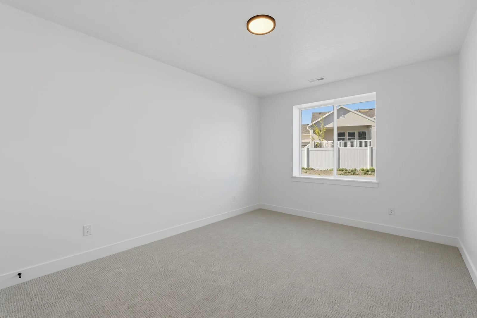 Empty bedroom with neutral carpet, white walls, recessed lighting, a window, and open doorway in Chestnut Modern MW302, Stansbury Park.