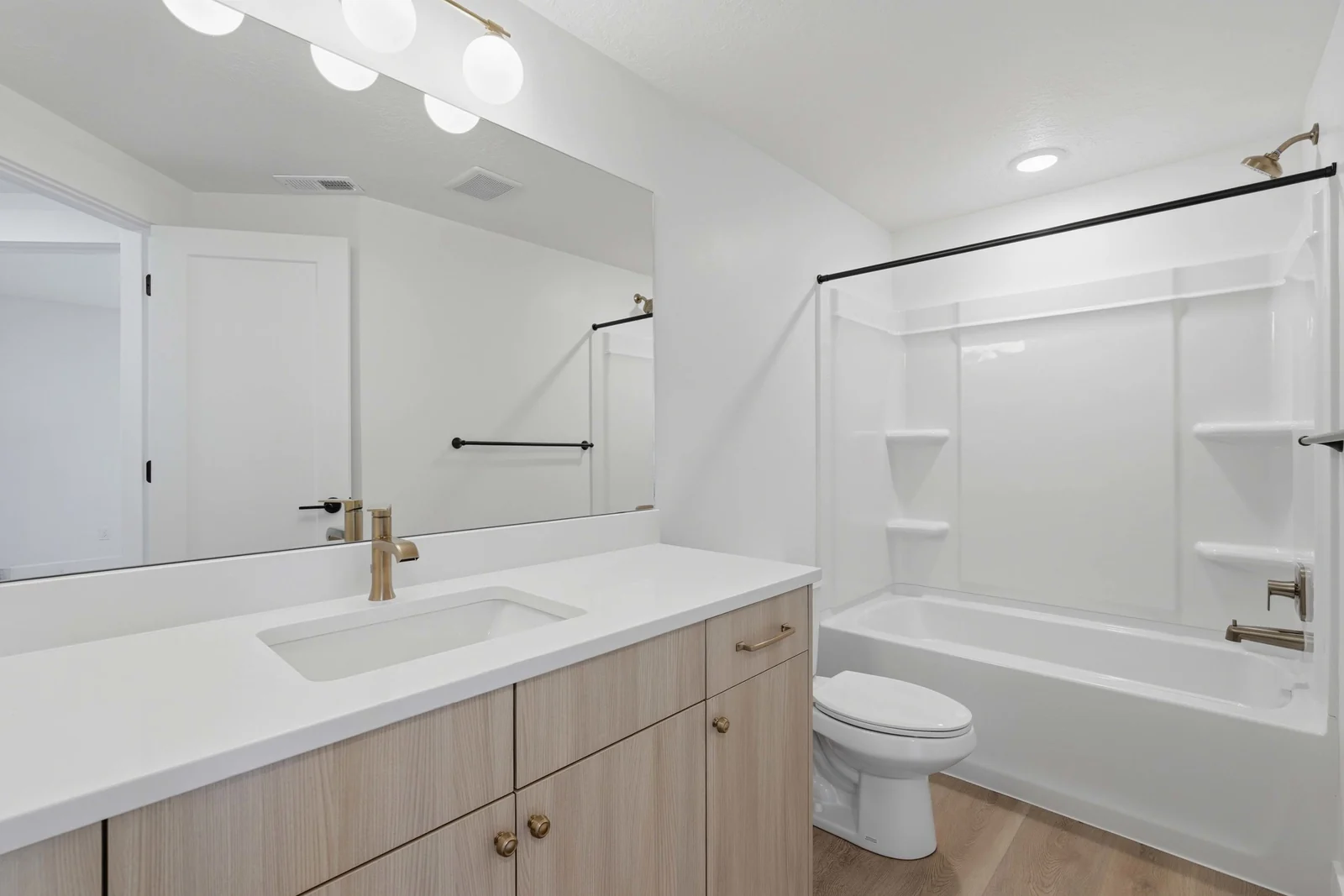 Bathroom with a wood vanity, white countertop, toilet, tub-shower combination, and black fixtures in Chestnut Modern MW302, Stansbury Park.