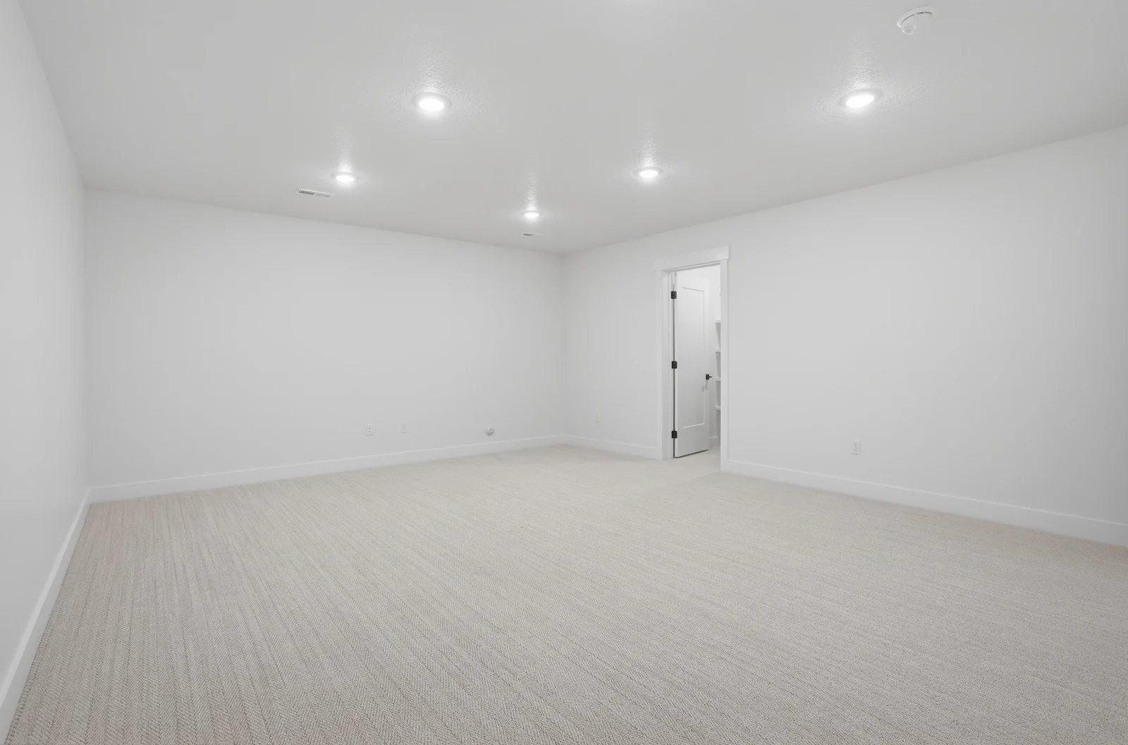 Unfurnished lower-level room with recessed lights, neutral carpet, white walls, and an open doorway in Olympic BH08, American Fork.