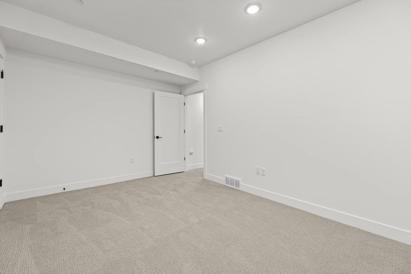 Unfurnished carpeted lower-level room with recessed lights, white walls, double doors, and a single interior door in Hawthorne Modern, Ogden.