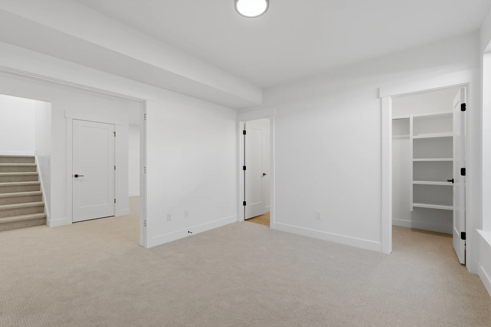 Carpeted hallway area with a stair opening, white walls, recessed lighting, and multiple interior doorways in Chestnut Modern MW302, Stansbury Park.