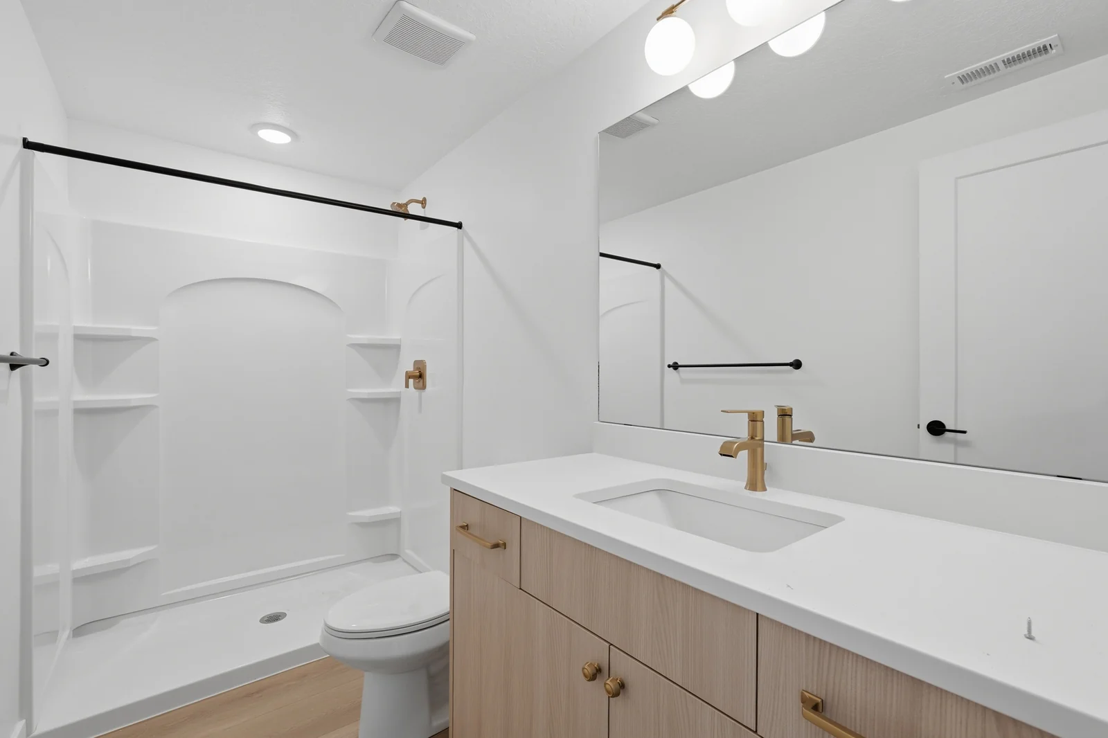 Carpeted living area with recessed lighting, arched wall niches, open shelving, and a bathroom doorway in Chestnut Modern MW302, Stansbury Park.