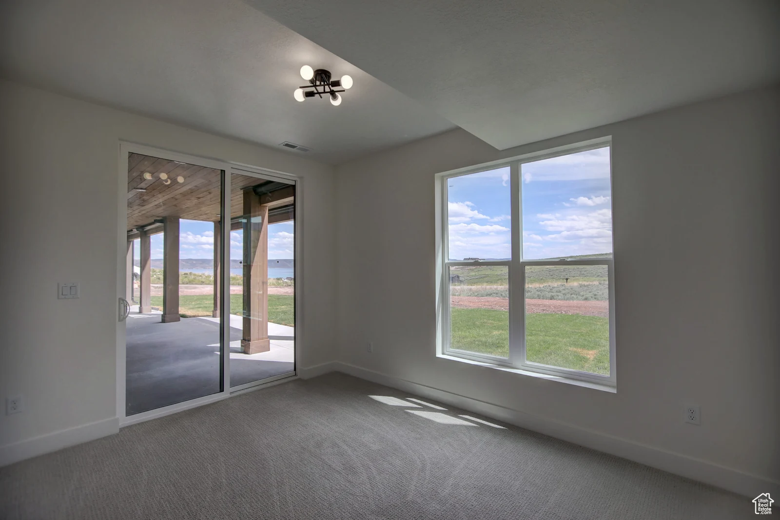 Unfurnished basement bedroom with carpet, a sliding glass door, and windows overlooking open land in Pinnacle, Bear Lake.