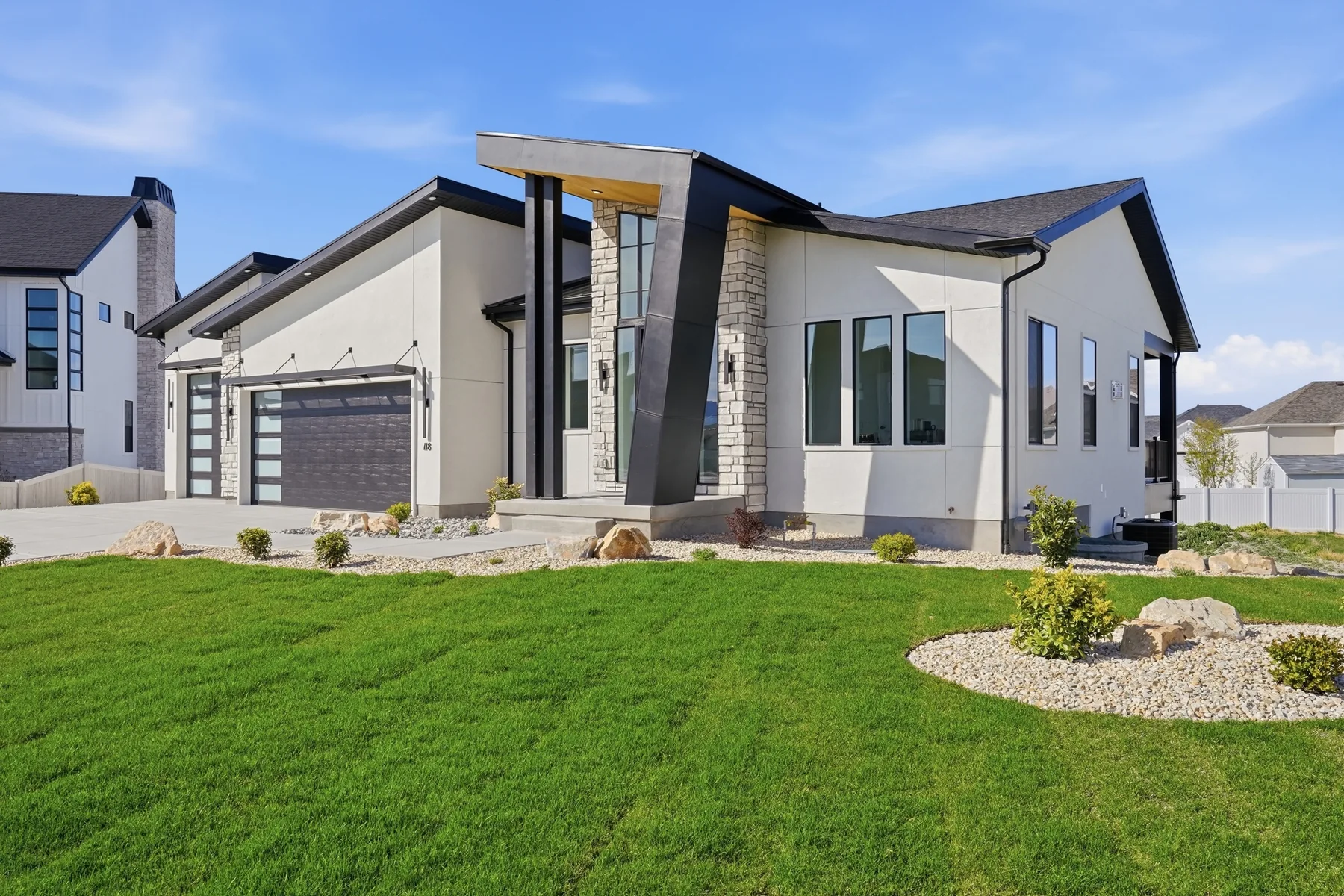 Landscaped modern Gold Crest home with a stone entry and broad front lawn